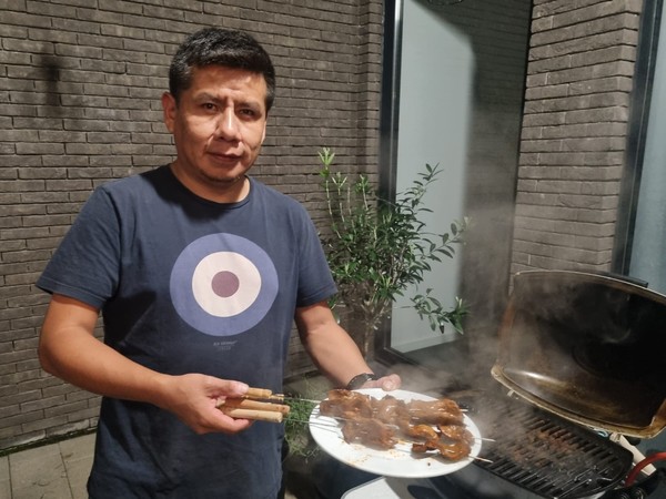 Lucho haalt het vlees van de barbecue